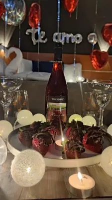 a plate of food with a bottle of wine and candles at Hotel Villa Capricce in Puente Piedra