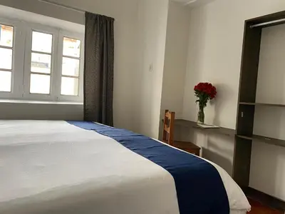 a bedroom with a bed and a vase of flowers at Runa House in Cusco