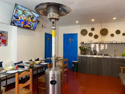 a kitchen with a dining room with a table and a pole at Runa House in Cusco