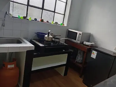 a kitchen with a stove and a microwave at Casa Hospedaje in Ayacucho
