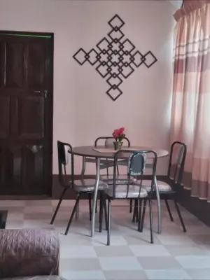 a dining room table and chairs with a vase on it at Casa Hospedaje in Ayacucho