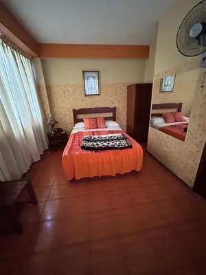 a bedroom with a bed with an orange bedspread at Aquarium in Lima
