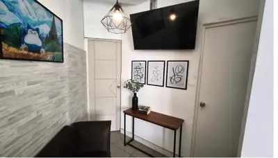 a hallway with a table and a television on a wall at Departamento en el Centro Historico de Lima Perú in Lima