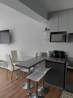 a kitchen with a counter and a table and chairs at Lovely & quiet place, park view & private parking in Lima