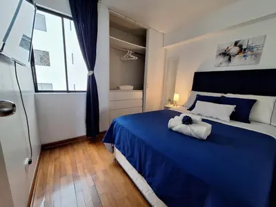 a bedroom with a blue bed with a stuffed animal on it at Habitación Baño Compartido en Departamento Compartido in Lima
