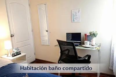 a bedroom with a desk with a laptop and a chair at Habitación Baño Compartido en Departamento Compartido in Lima