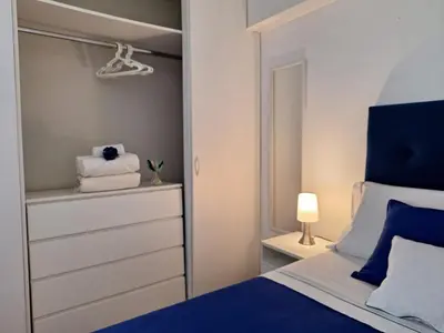 a bedroom with a blue and white bed and a closet at Habitación Baño Compartido en Departamento Compartido in Lima