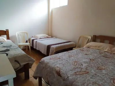 a room with two beds and two chairs in it at Casa de Campo y Hospedaje Irma in Lunahuaná