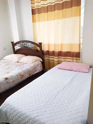 two twin beds in a room with a window at Casa de Campo y Hospedaje Irma in Lunahuaná