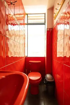 a red bathroom with a red toilet and a sink at Depawanka 3 Departamento amoblado y equipada in Huancayo