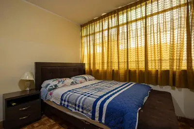 a bedroom with a bed and a large window at Depawanka 3 Departamento amoblado y equipada in Huancayo
