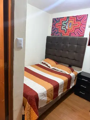 a small bedroom with a bed with a blanket at Residencia Monterrico in Lima