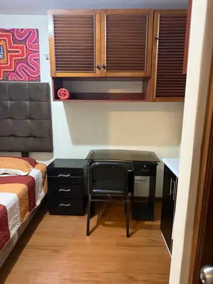 a desk in a bedroom with a bed and a desk at Residencia Monterrico in Lima