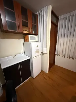 a small kitchen with a refrigerator and a microwave at Residencia Monterrico in Lima