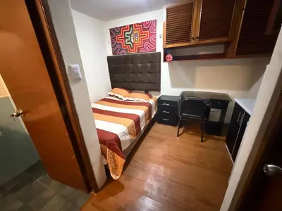 a small bedroom with a bed and a chair at Residencia Monterrico in Lima