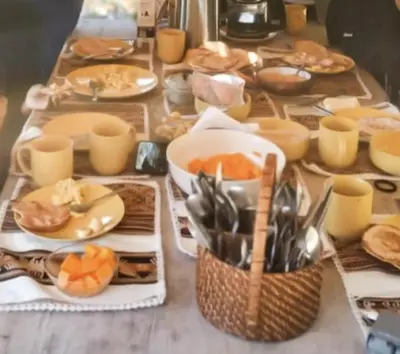 a table with plates of food and utensils on it at SAMAY WASI Rest house in Ollantaytambo