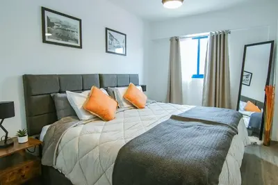 a bedroom with a large bed with orange pillows at Moderno Loft a Pasos del Centro in Cusco
