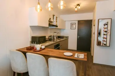 a kitchen with a wooden table and some chairs at Moderno Loft a Pasos del Centro in Cusco