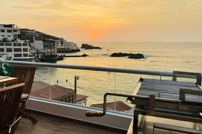 a view of the ocean at sunset from a balcony at Departamento COCO - San Bartolo in San Bartolo