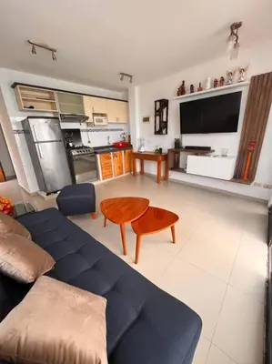 a living room with a blue couch and a table at Departamento COCO - San Bartolo in San Bartolo