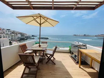 a patio with a table and chairs and an umbrella at Departamento COCO - San Bartolo in San Bartolo