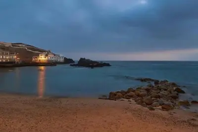 a beach with rocks in the water at night at Departamento COCO - San Bartolo in San Bartolo