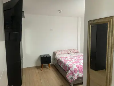 a bedroom with a bed and a dresser and a mirror at Acogedor departamento en Los Olivos 3 dormitorios in Lima