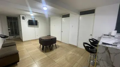 a living room with a table and chairs in it at Acogedor departamento en Los Olivos 3 dormitorios in Lima