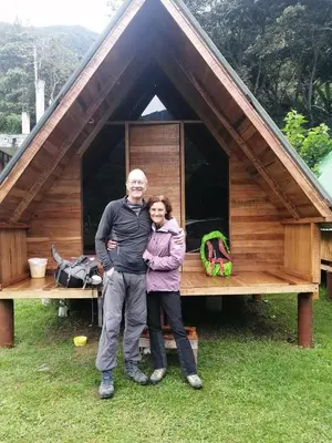 a man and a woman standing in front of a cabin at INCA COFFEE Lodge Lucmabamba in Sahuayacu