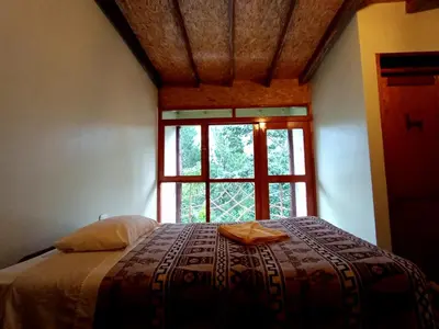 a bedroom with a large bed with a window at INCA COFFEE Lodge Lucmabamba in Sahuayacu