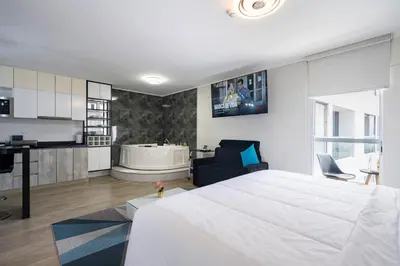 a bedroom with a large bed and a bath tub at G15 Apartments by Vibrant in Lima