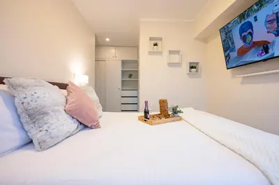 a bedroom with a large white bed with a tv on the wall at G15 Apartments by Vibrant in Lima