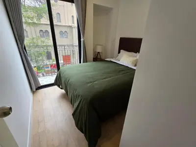 a bedroom with a green bed and a large window at Apartamento full equipado en barranco in Lima