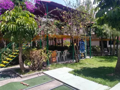 a garden with a playground with a table and chairs at Kibo Hotel in Ayacucho