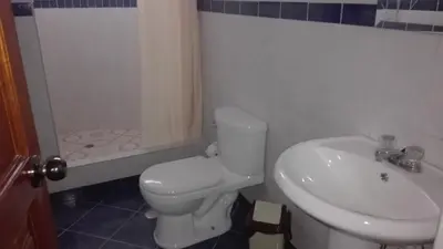 a bathroom with a toilet and a sink and a shower at Kibo Hotel in Ayacucho