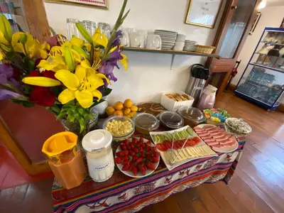 a table with food and flowers on top of it at Amira's House Cusco in Cusco