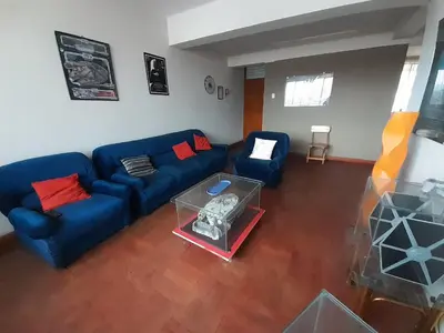 a living room with a blue couch and a table at Departamento céntrico en Cusco in Cusco