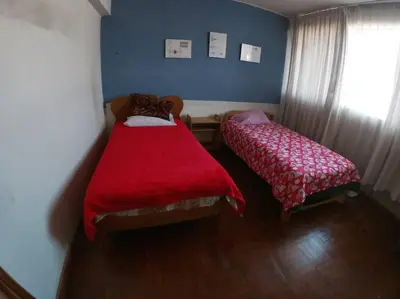 a bedroom with two beds and a window at Departamento céntrico en Cusco in Cusco