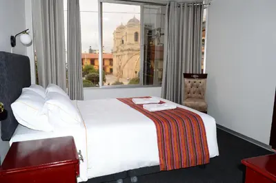 a bedroom with a large white bed with a window at Hotel Santa Felicita - Centro Histórico in Huancayo
