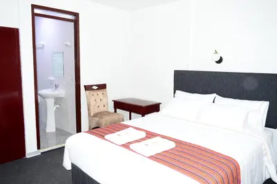 a bedroom with a bed and a bathroom with a sink at Hotel Santa Felicita - Centro Histórico in Huancayo