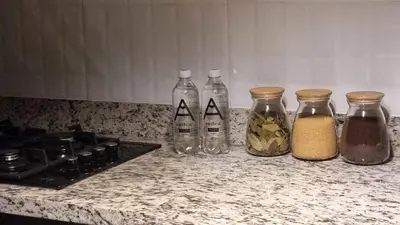 a group of four glass bottles on a kitchen counter at Apartamento en Miraflores in Lima