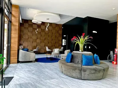 a lobby with a couch and a table and chairs at Deluxe Apartment in San Isidro in Lima
