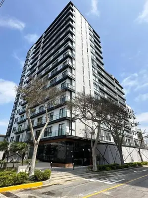 a tall white building with trees in front of it at Deluxe Apartment in San Isidro in Lima