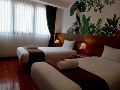a hotel room with two beds and a window at Susanna Inn MachuPicchu Hotel in Machu Picchu