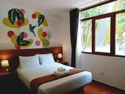 a bedroom with a bed with a teddy bear on it at Susanna Inn MachuPicchu Hotel in Machu Picchu