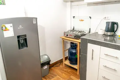 a kitchen with a refrigerator and a stove at Willka Wasi Cusco in Cusco