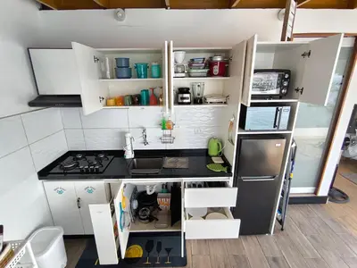 a small kitchen with a stove and a refrigerator at Lindo chalet en PUCUSANA in Pucusana
