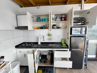 a kitchen with white cabinets and a stainless steel refrigerator at Lindo chalet en PUCUSANA in Pucusana