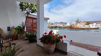 a balcony with flowers and a view of the water at Ninfas 371 in Pucusana