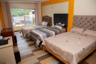 a hotel room with two beds and a balcony at Apartamento La Merced in La Merced